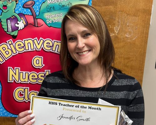  Mrs. Smith smiles holding her Faculty of the Month certificate